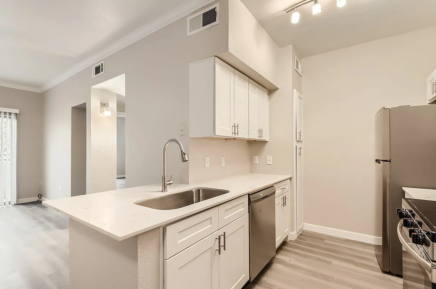 Kitchen, white shaker cabinetry, quartz countertops, stainless appliances, wood-style plank flooring