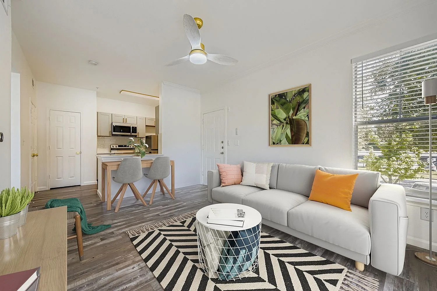 Living room, wood-style plank flooring, gray sectional sofa, ceiling fan, striped area rug