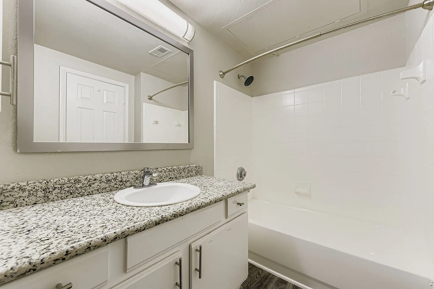 Bathroom, granite countertops, white vanity cabinetry, round sink, framed mirror