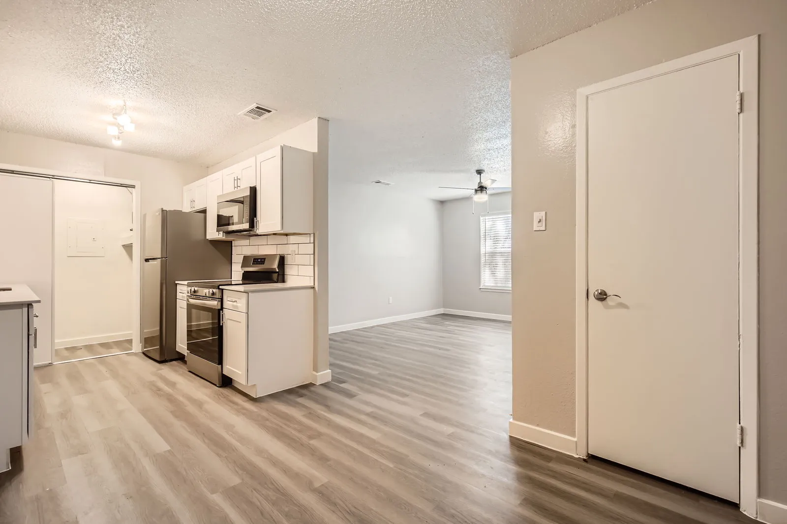 Dining area, open to kitchen, wood-style plank flooring, ceiling fan