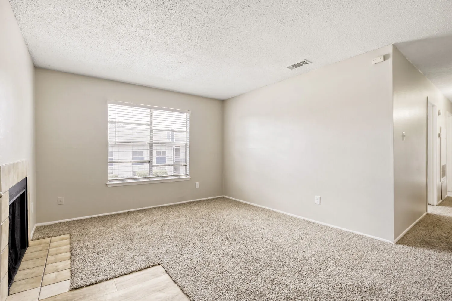 C1 Classic floor plan, spacious living room, neutral carpet, tile-front fireplace, large window