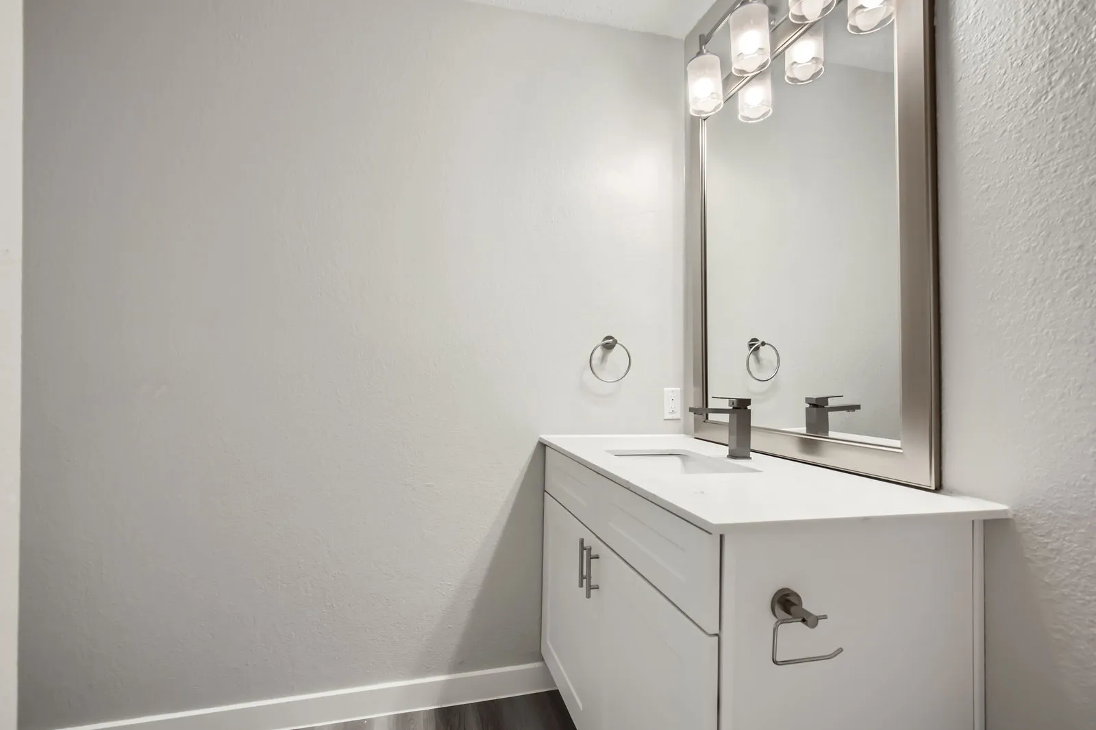 Bathroom with quartz vanity countertop, framed mirror