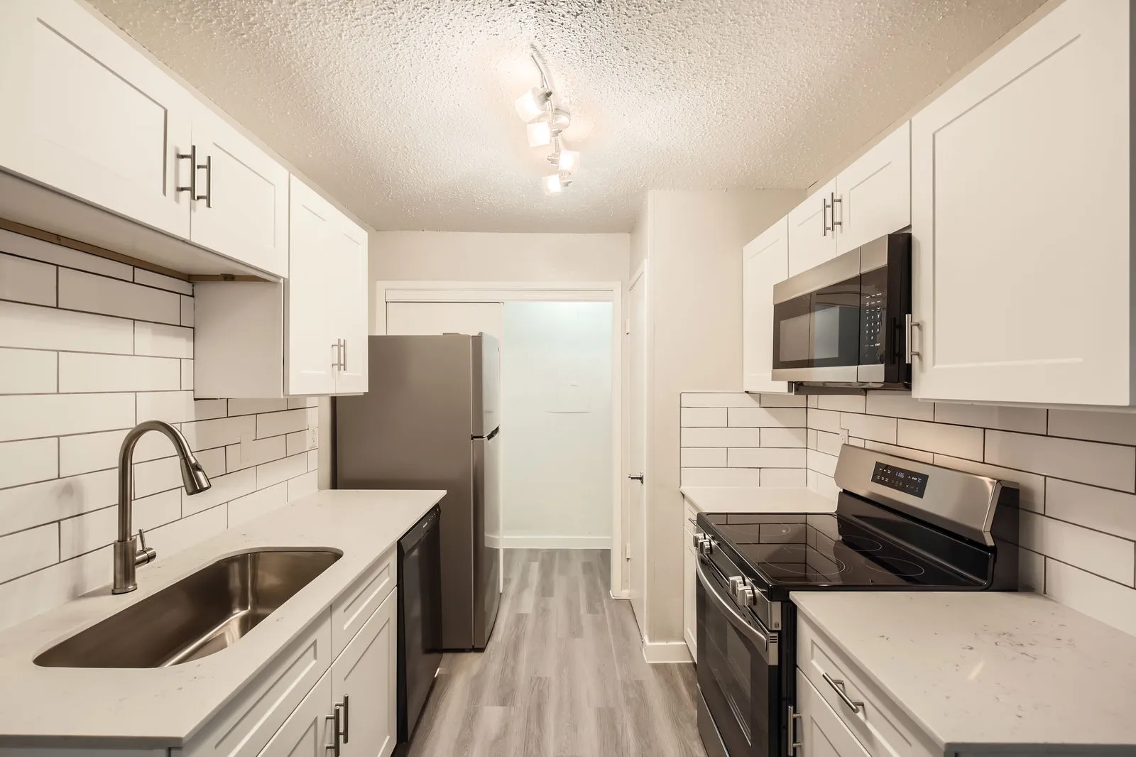 Renovated kitchen, white shaker cabinetry, subway tile backsplash, appliances