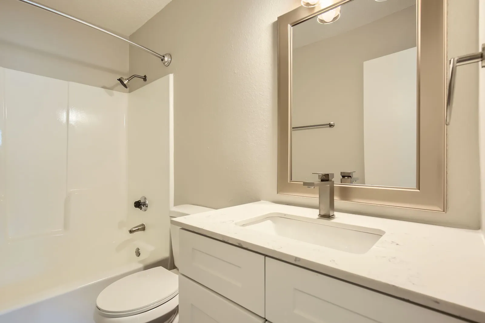 Hallway bathroom, white vanity, quartz countertop, tub-shower combo