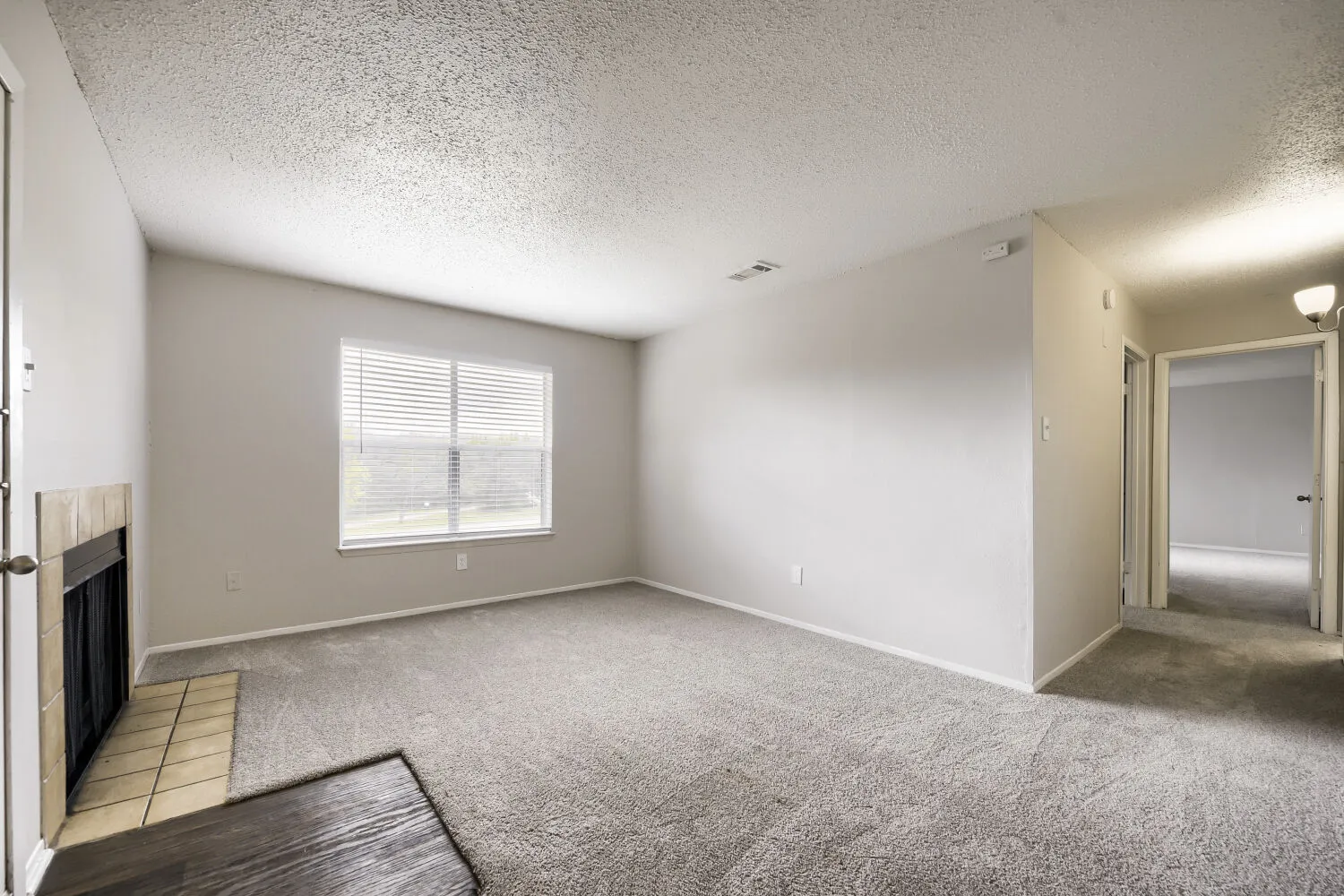 B1 Classic floor plan, spacious living room, neutral carpet, tile-front fireplace, large window