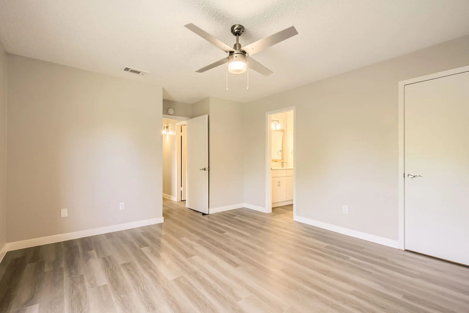 Primary bedroom, ensuite bathroom access, ceiling fan, walk-in closet