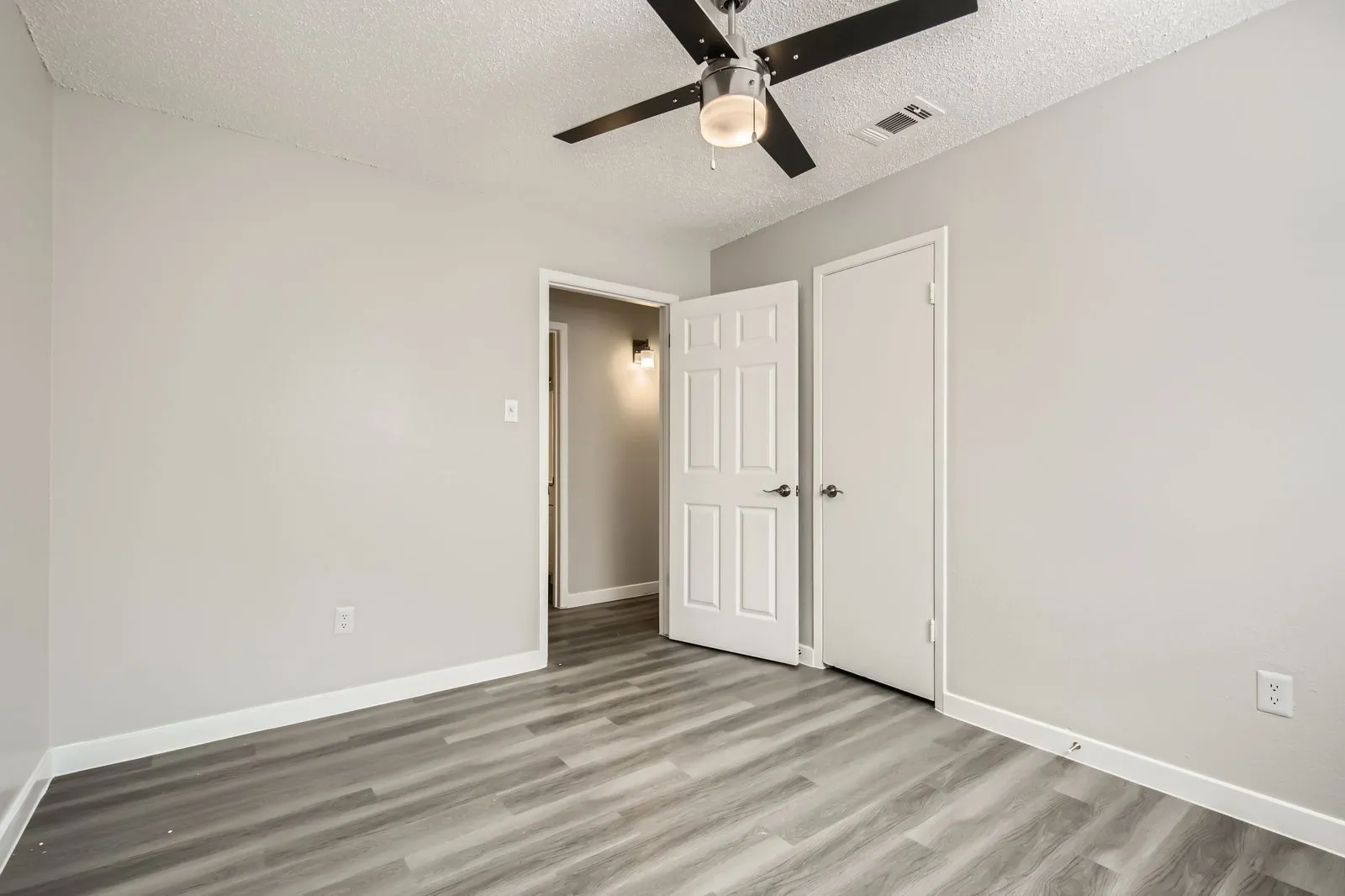 Second bedroom, wood-style plank flooring, ceiling fan, closet