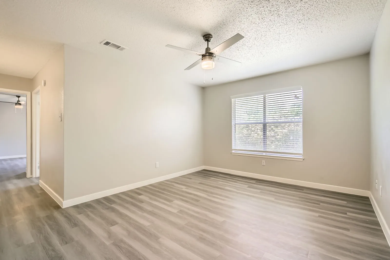 B1 Renovated floor plan, wood-style plank flooring, ceiling fan, large window