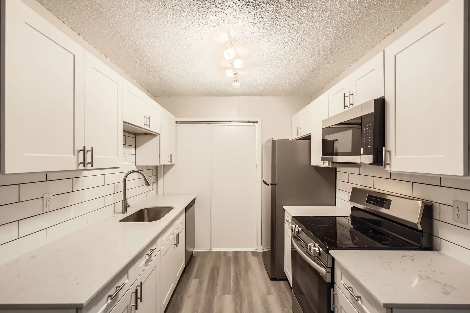 Renovated kitchen, white shaker cabinetry, subway tile backsplash, stainless appliances
