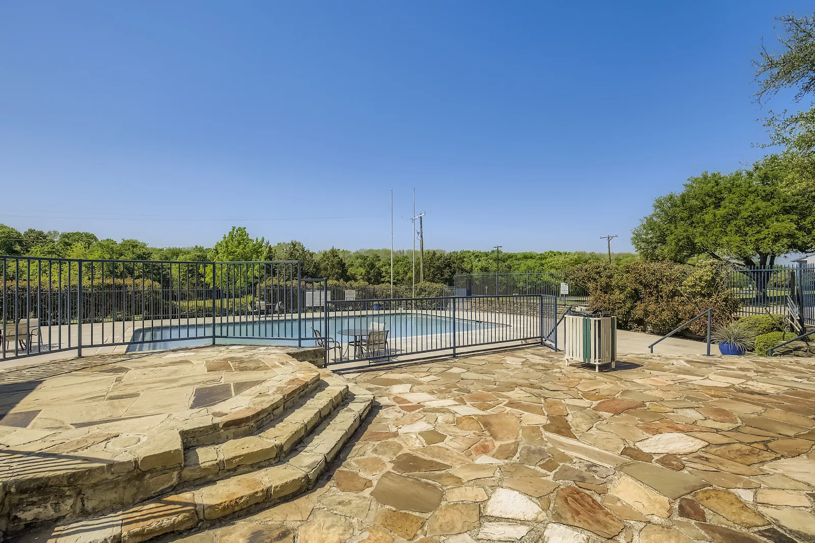 Community pool, gated surround, patio seating