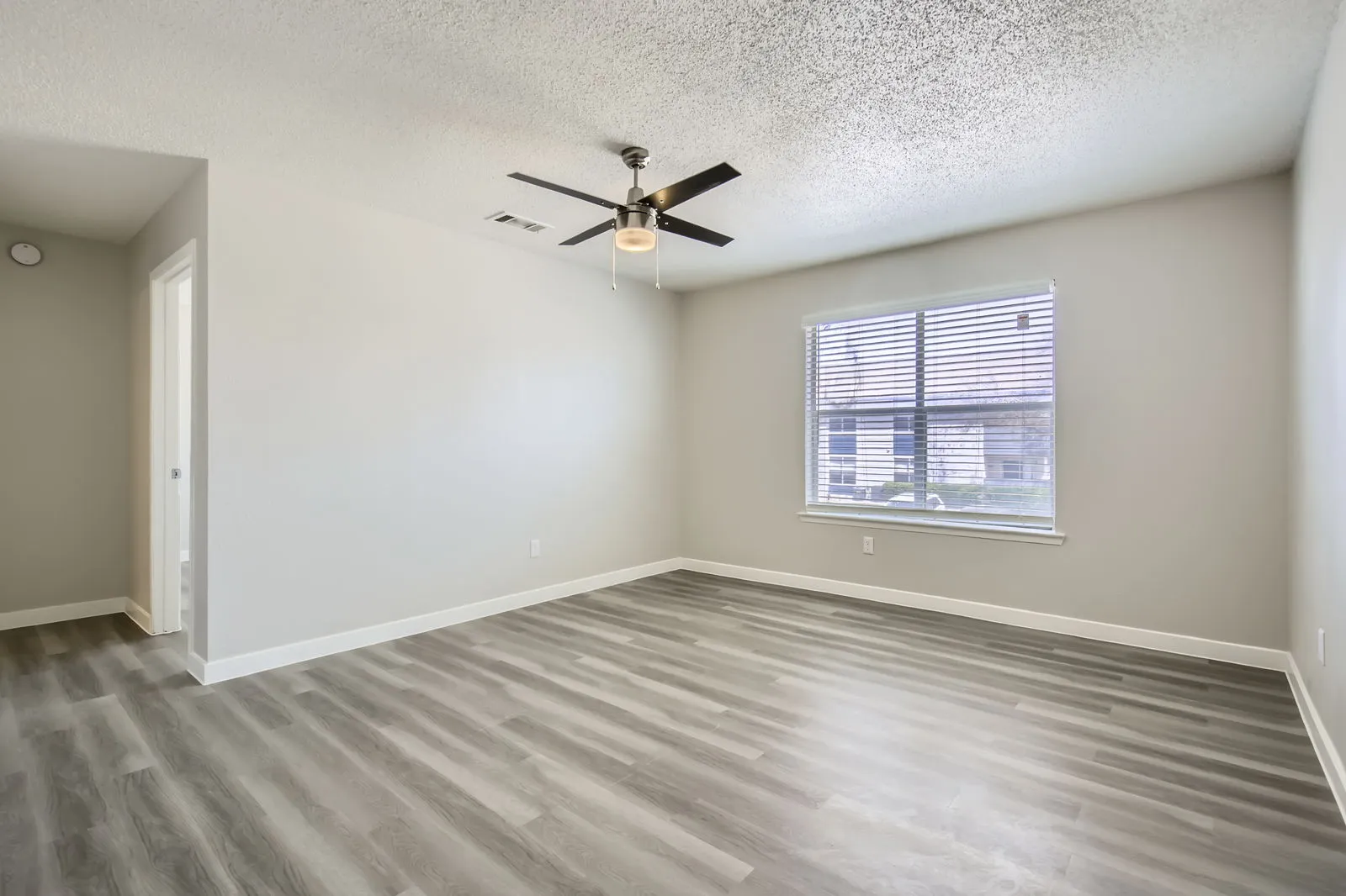 A2 Platinum floor plan, living room with wood-style plank flooring, ceiling fan, hallway view, window with natural light