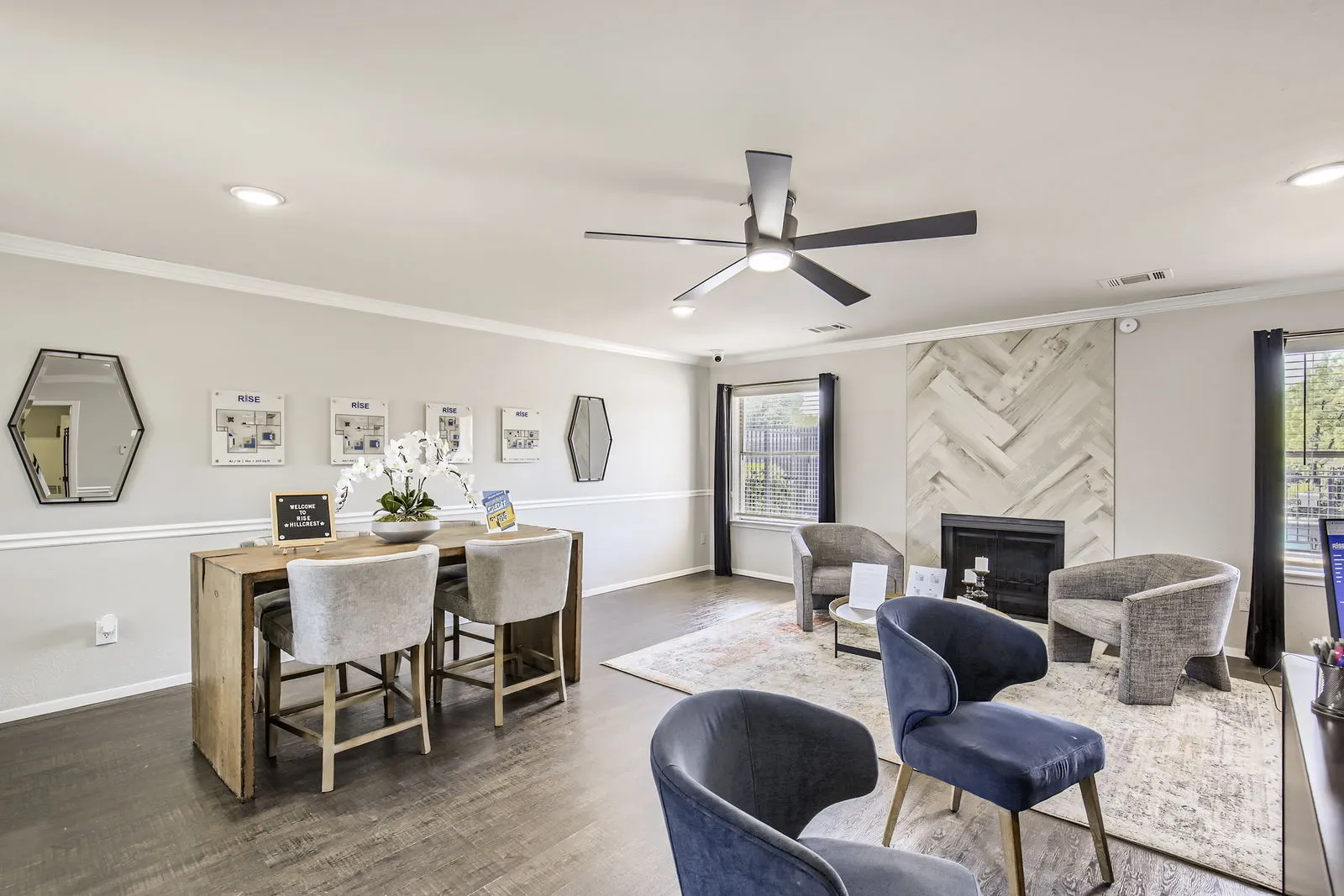 Leasing office lounge, fireplace, wood-style plank flooring, floor plan displays