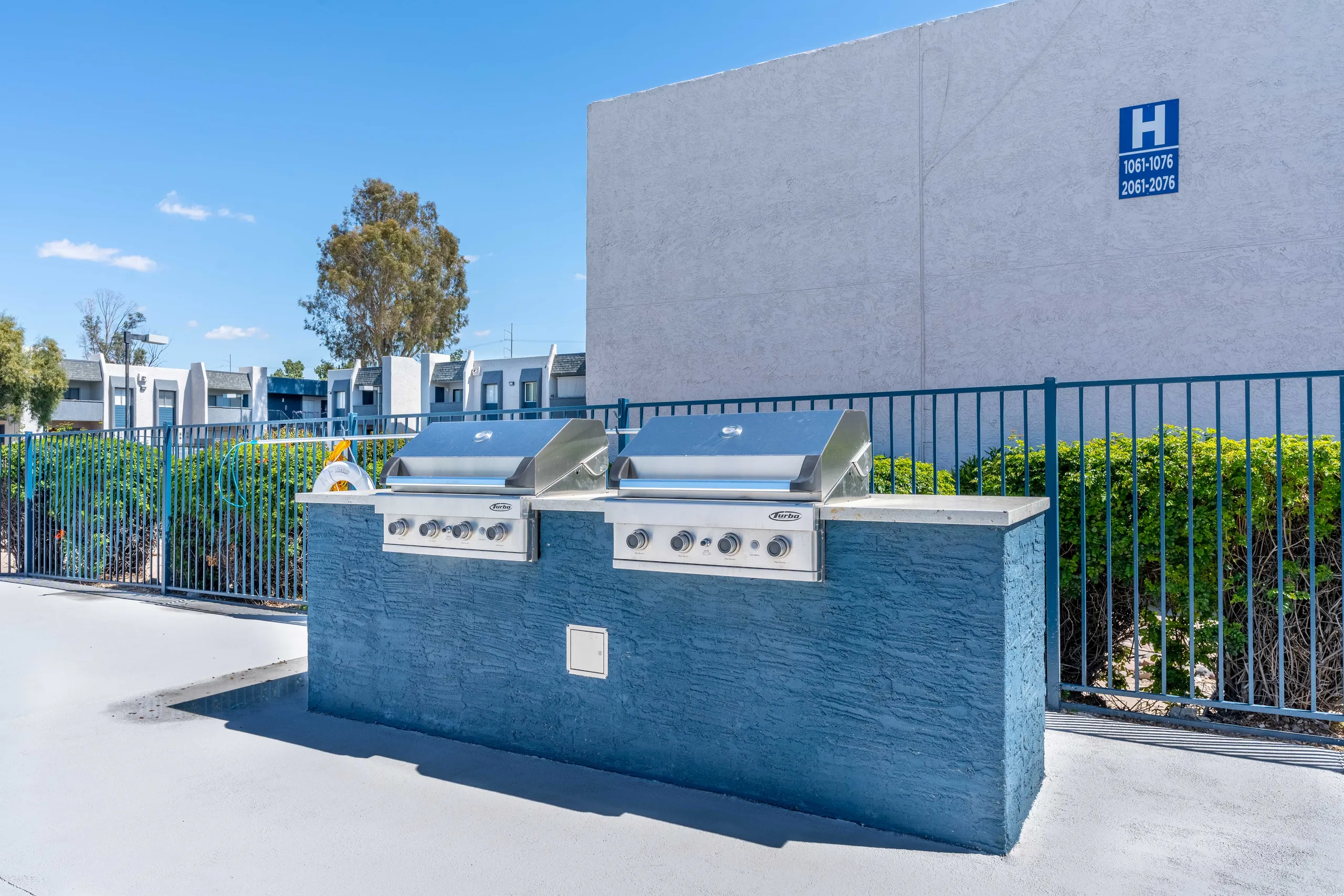 Outdoor grilling station, stainless steel grills, fenced pool area