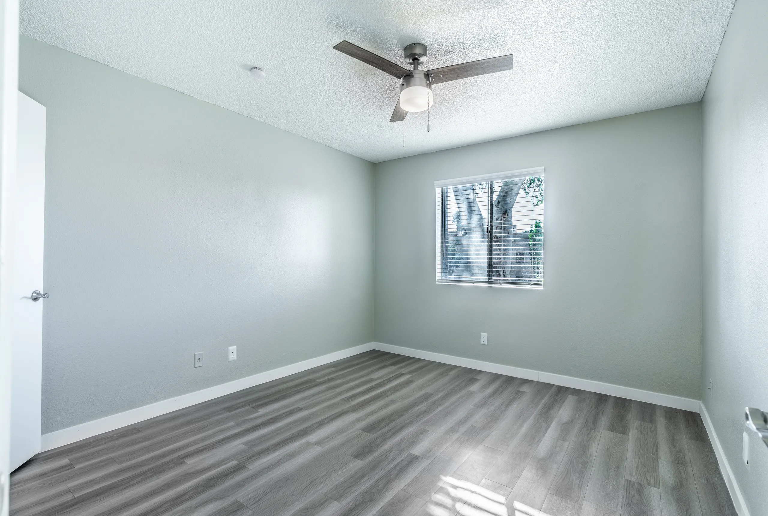 Bedroom with window, ceiling fan, wood-style plank flooring