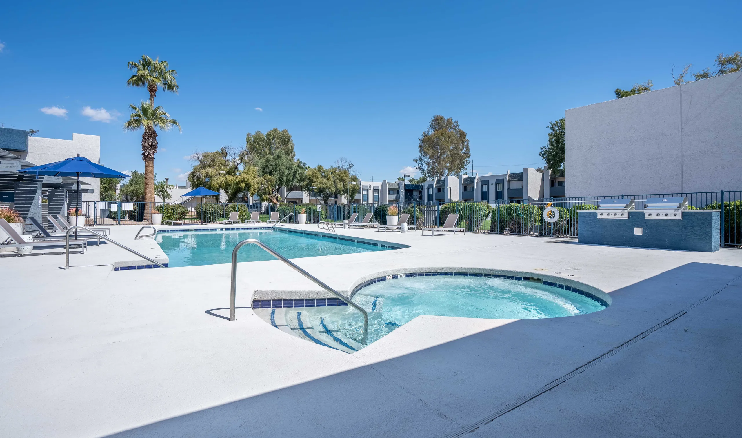 Resort-style pool, spa, lounge chairs, poolside grills