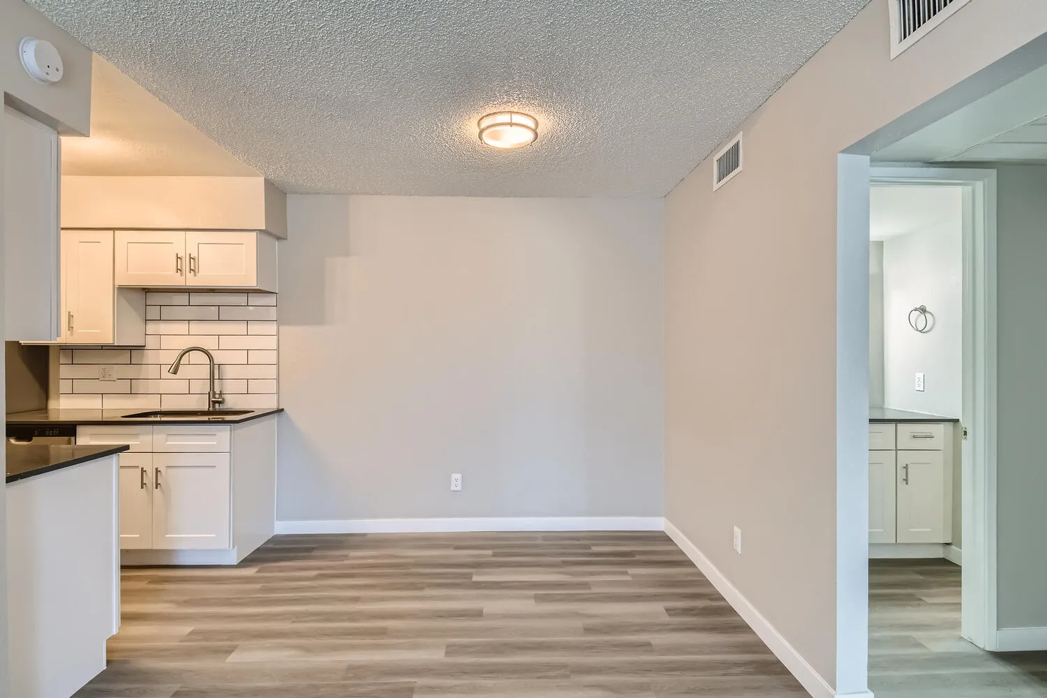 Dining area, white shaker cabinets, subway tile backsplash, flush mount light fixture