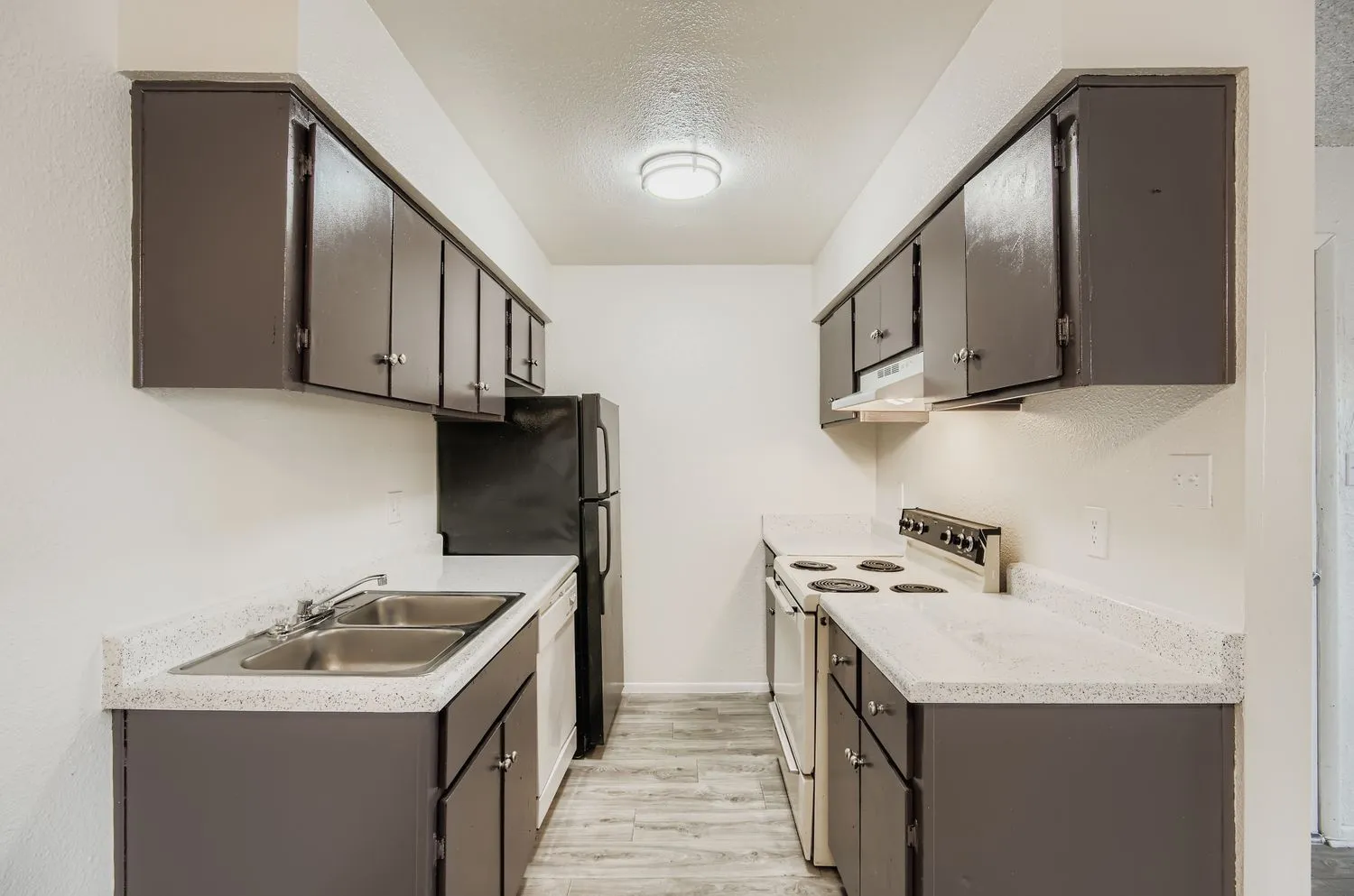 Galley kitchen, electric range, double basin sink, cabinetry