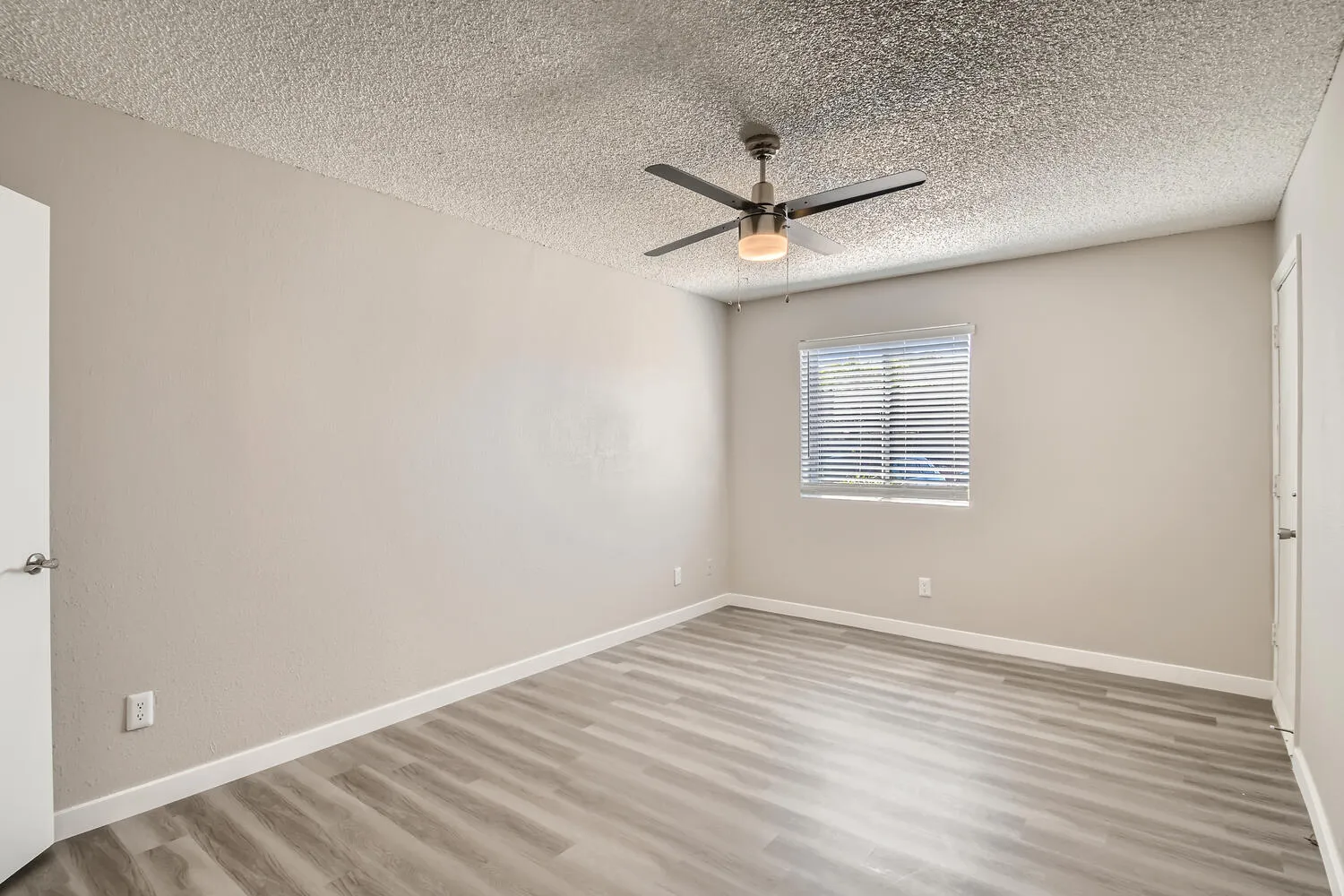 Primary bedroom, ceiling fan, mini blinds, neutral paint
