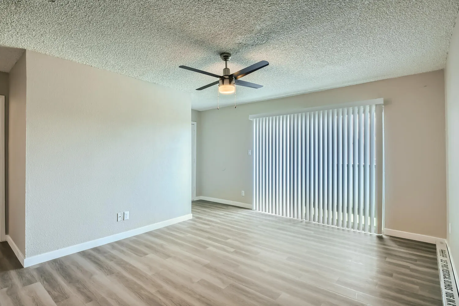 Living room, ceiling fan, vertical blinds, sliding glass door