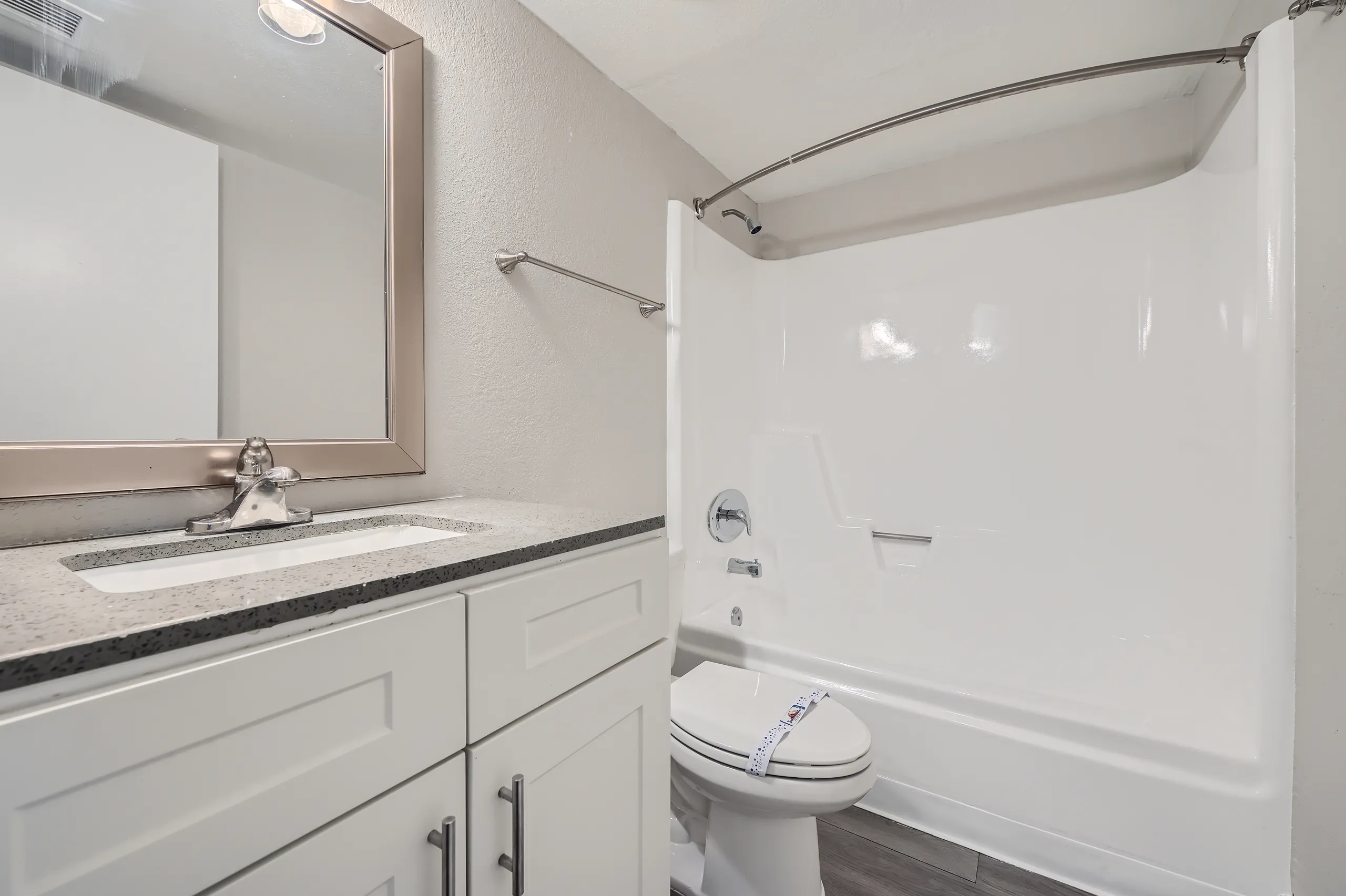 Bathroom, quartz vanity countertop, framed mirror, tub/shower combo