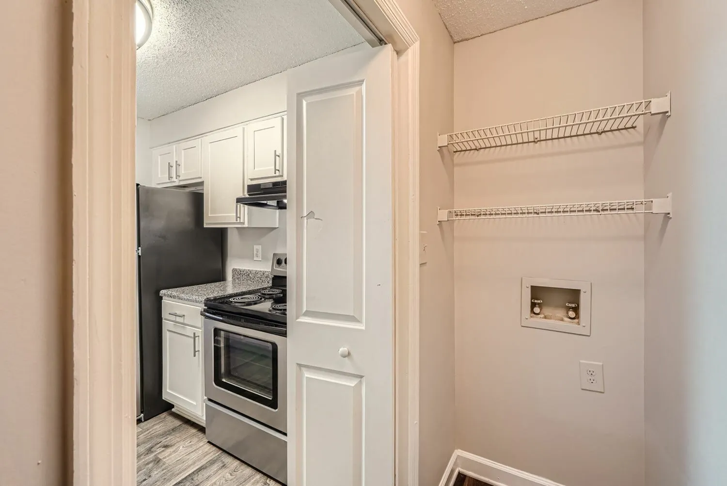 Kitchen with white cabinetry, countertops, electric range, wire shelving