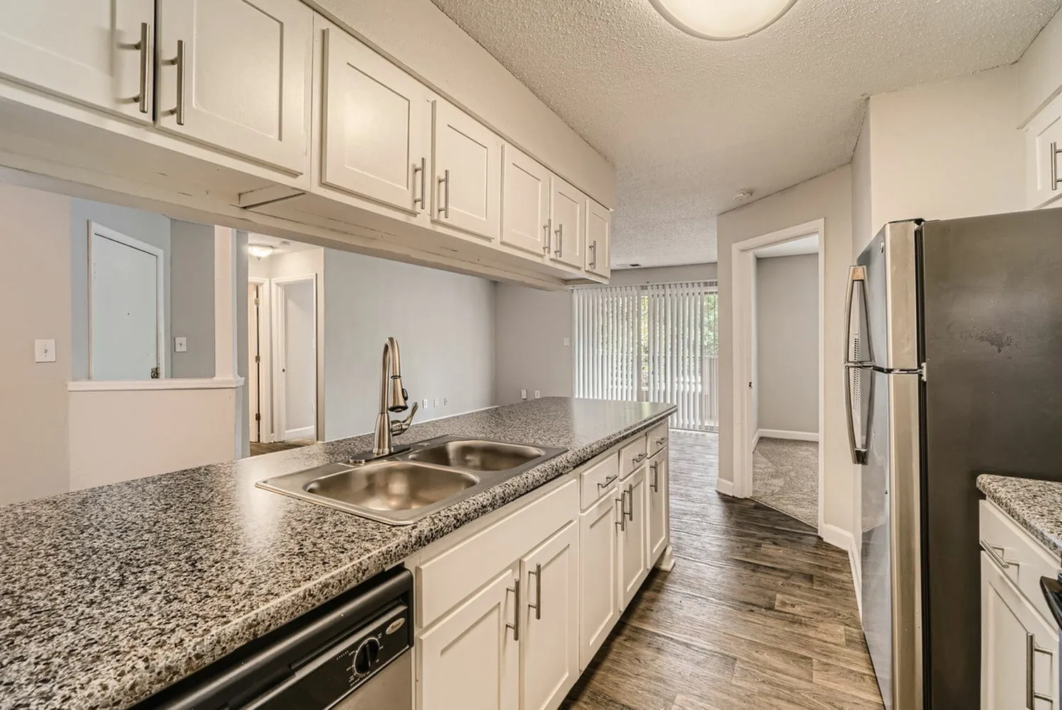 Kitchen with white cabinetry, countertops, double basin sink, window