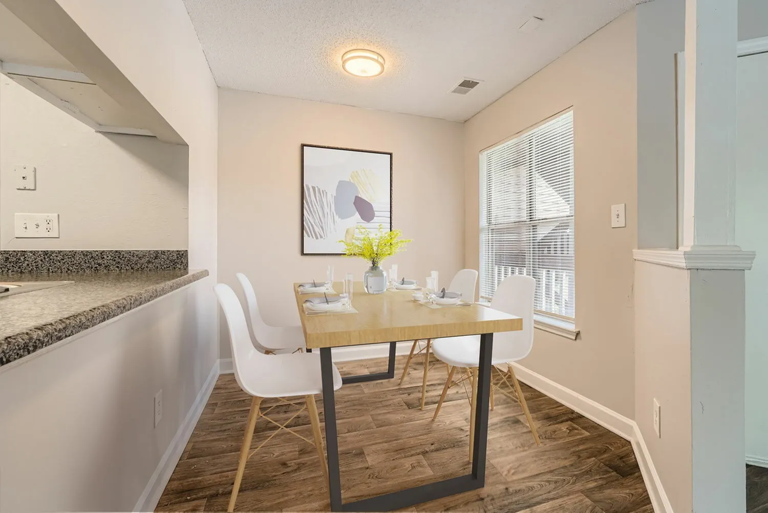 Dining area with wood-style plank flooring, window with natural light