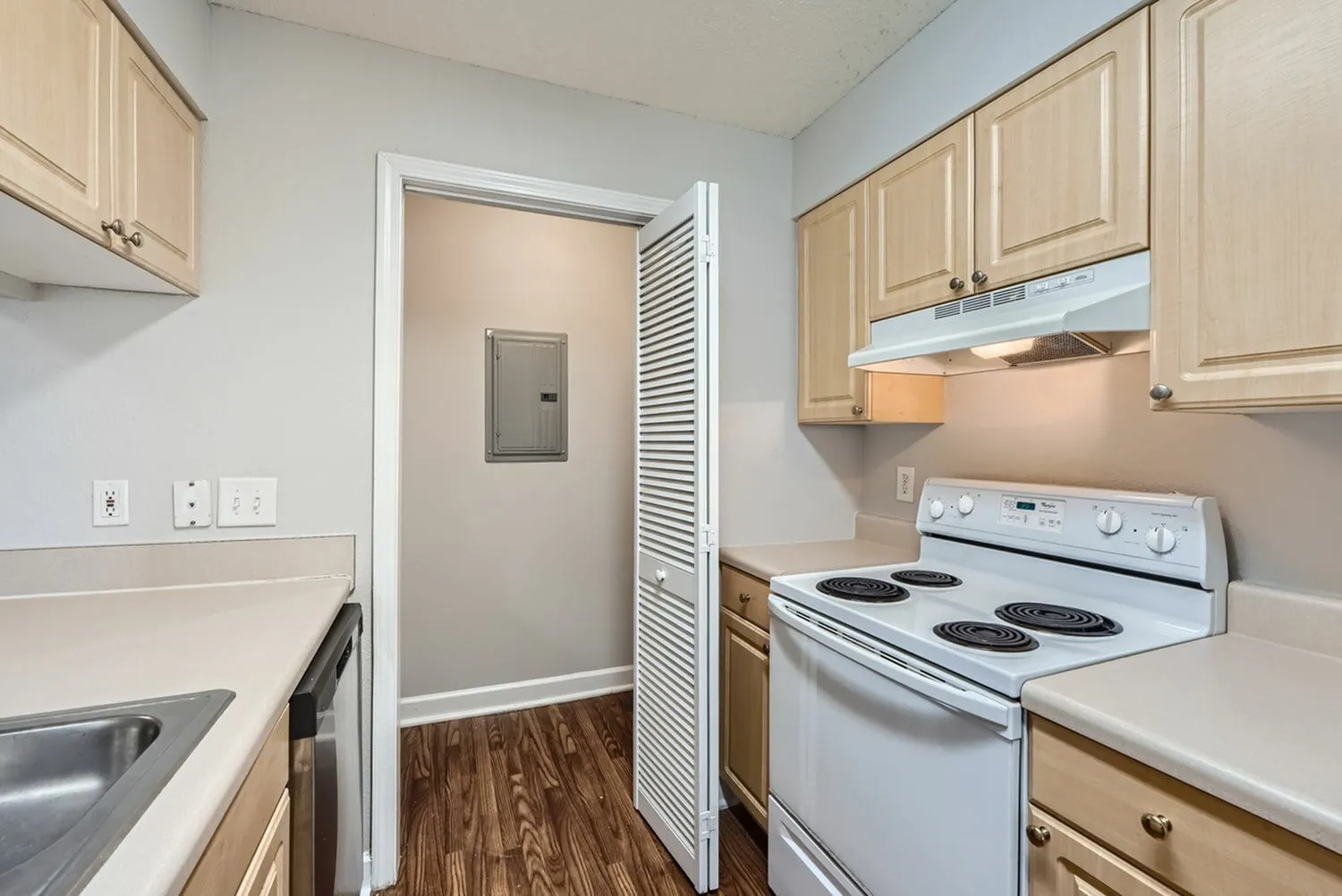 Kitchen with pantry closet, electric range, wood-style plank flooring