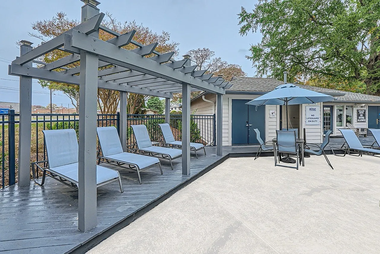 Pergola lounge seating beside the pool with umbrella shade