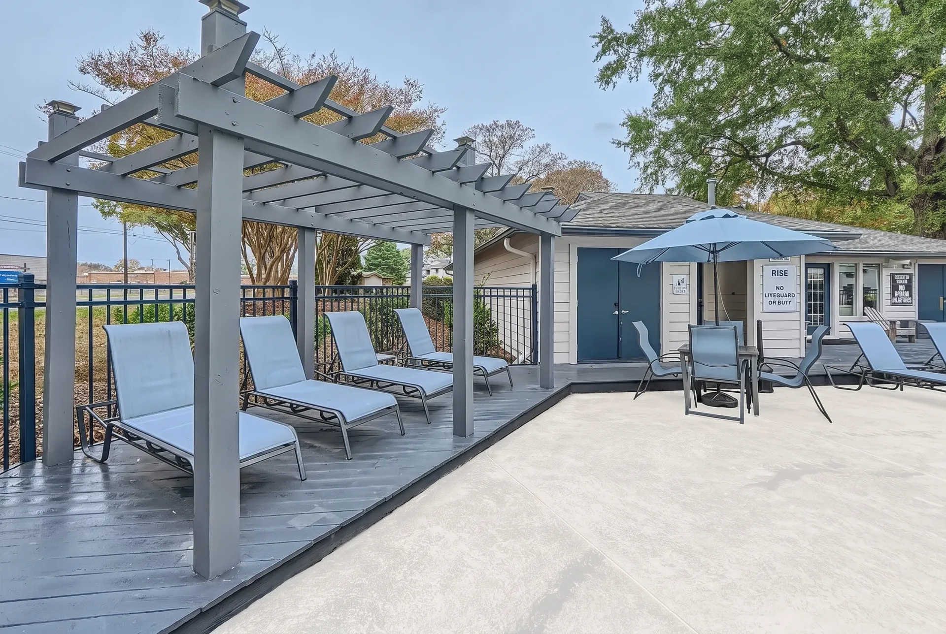 Pergola lounge seating beside the pool with umbrella shade