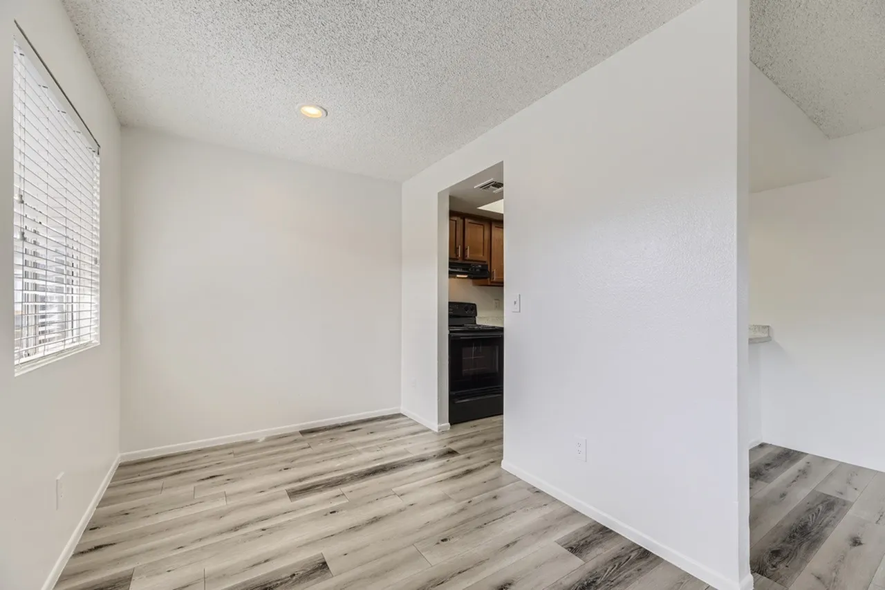 Entryway and kitchen area, wood-style plank flooring, white walls, recessed lighting