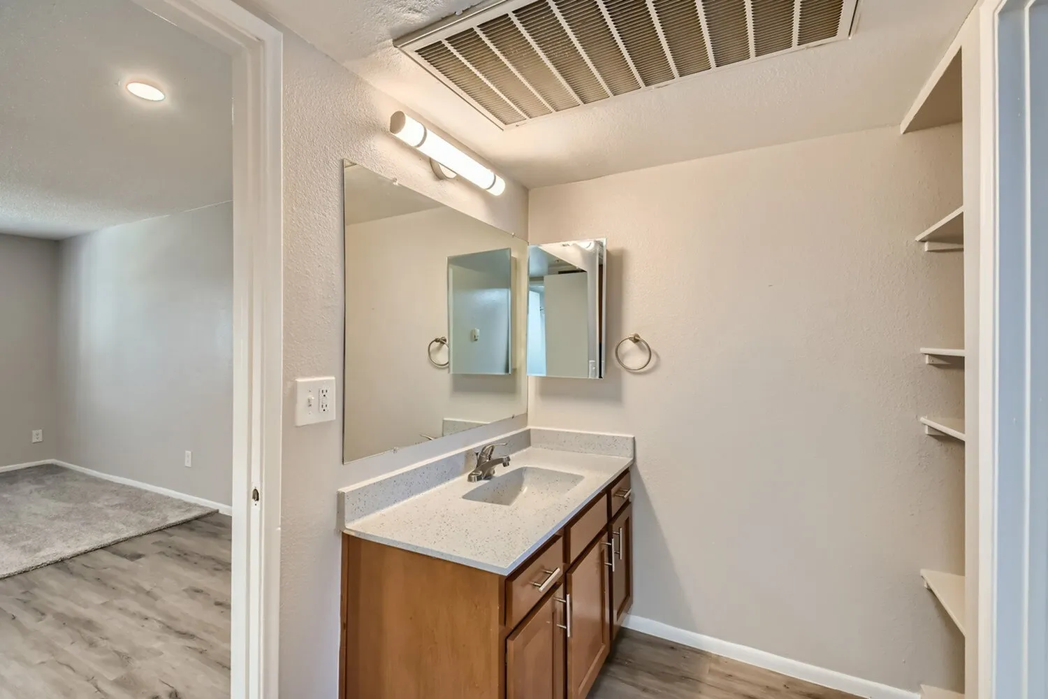 Primary bathroom, wood vanity cabinet, white quartz countertop, medicine cabinet mirror, chrome fixtures