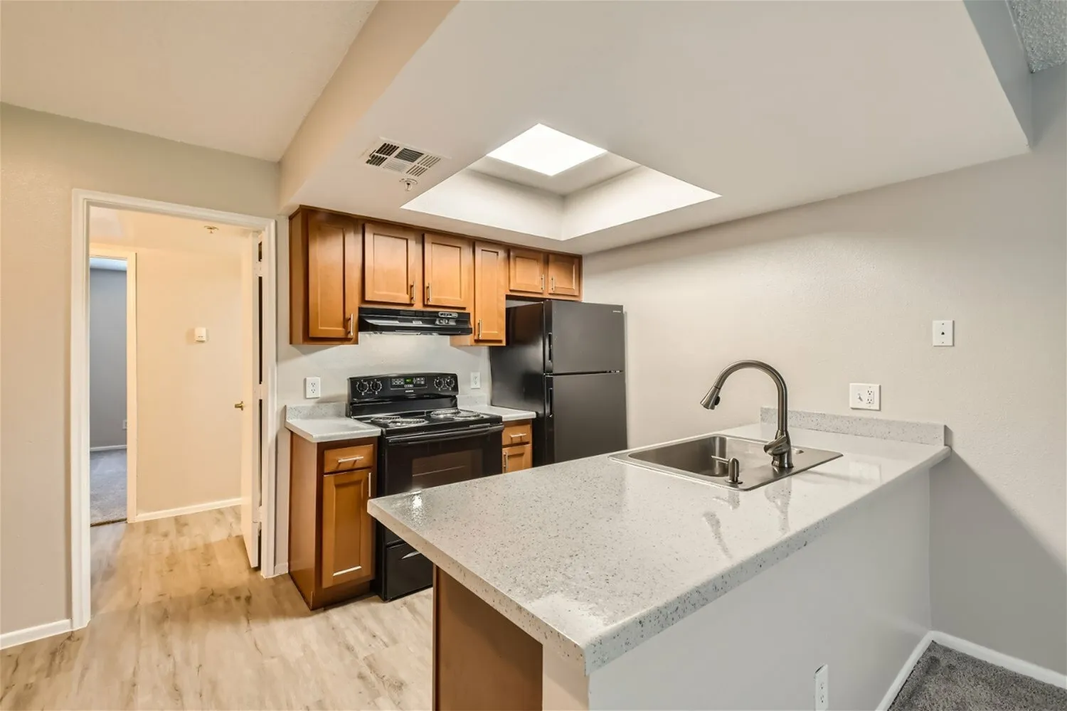 Kitchen, wood cabinetry, quartz countertops, stainless appliances, wood-style plank flooring