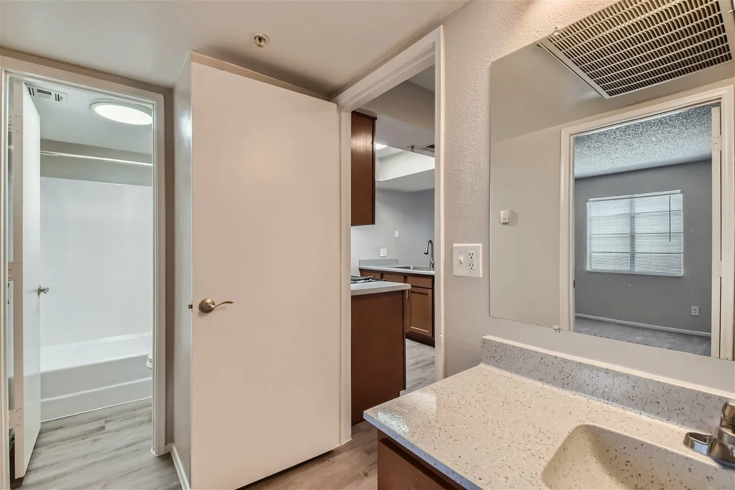 Primary bathroom, quartz countertops, dual sink vanity, wood-style cabinetry, tile flooring