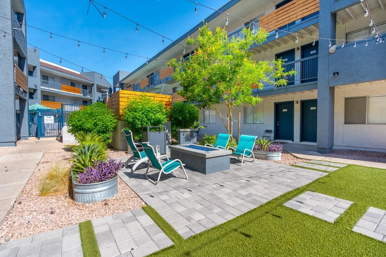 Courtyard with lounge chairs, fire pit, landscaping, modern buildings