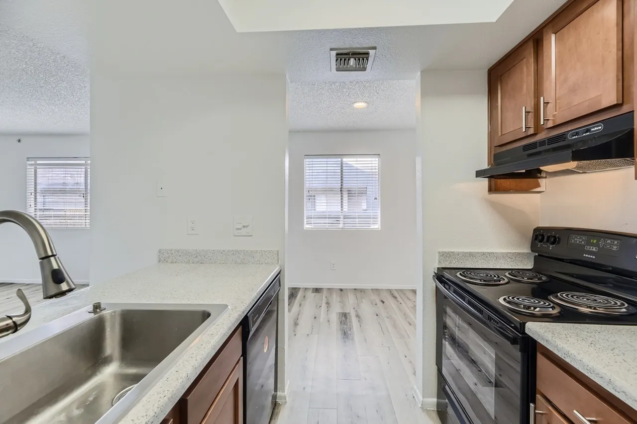 Kitchen, wood cabinetry, quartz countertops, stainless appliances, wood-style plank flooring