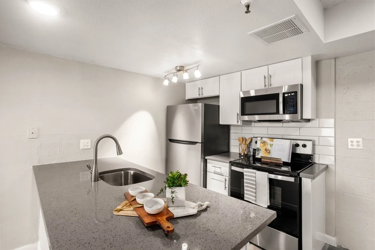 Kitchen, gray quartz countertops, white shaker cabinetry, stainless appliances, island sink