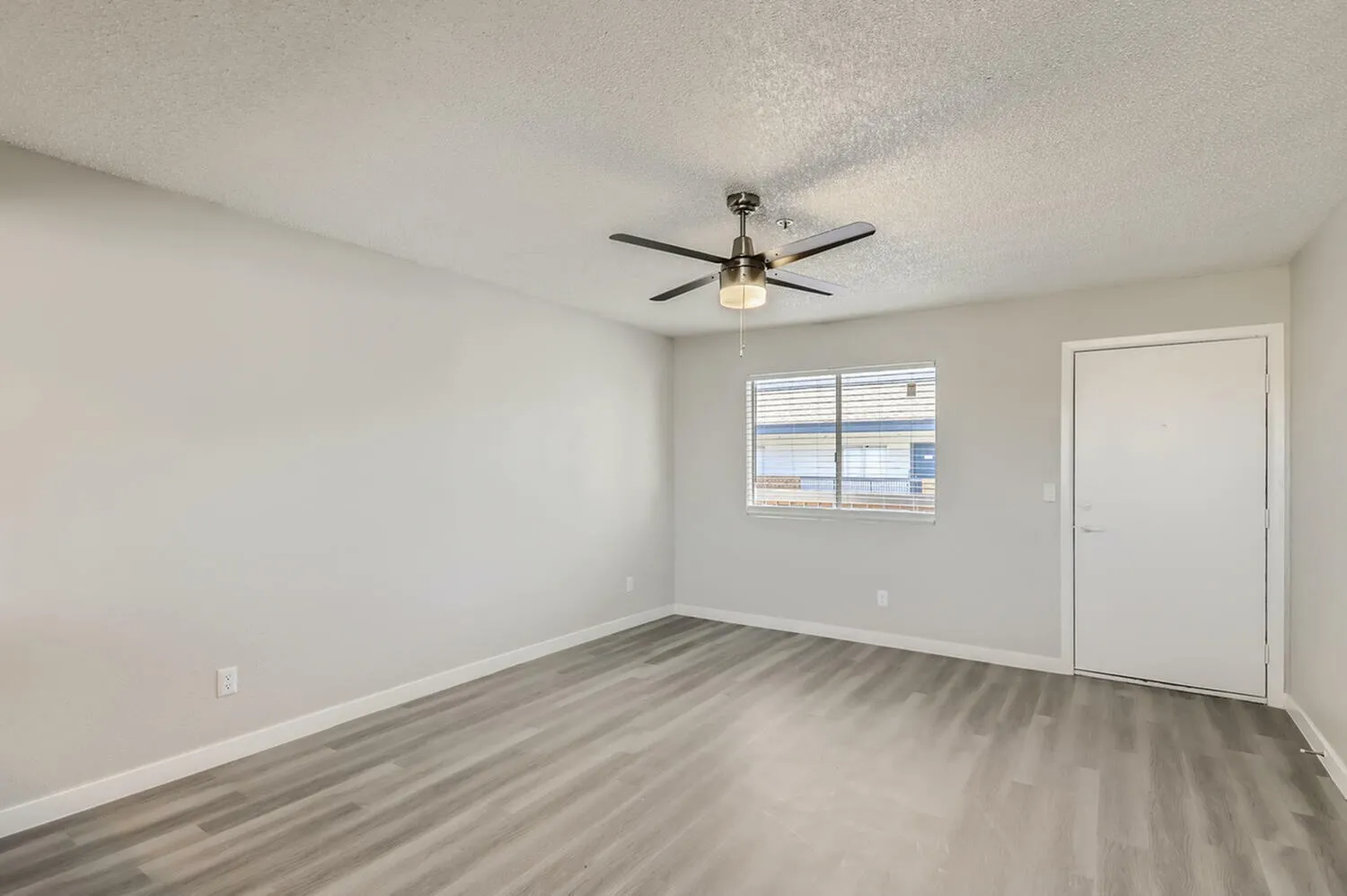 Bedroom, wood-style plank flooring, ceiling fan with light fixture, window with blinds, white door