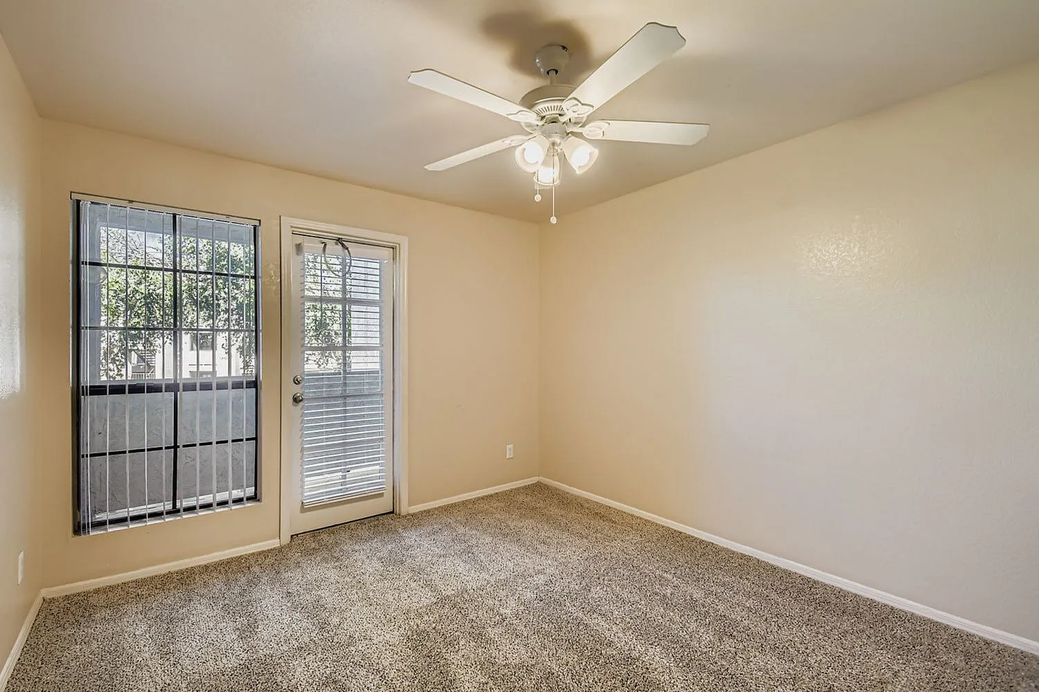 Bedroom, carpet flooring, ceiling fan with light fixture, glass doors and windows with security bars