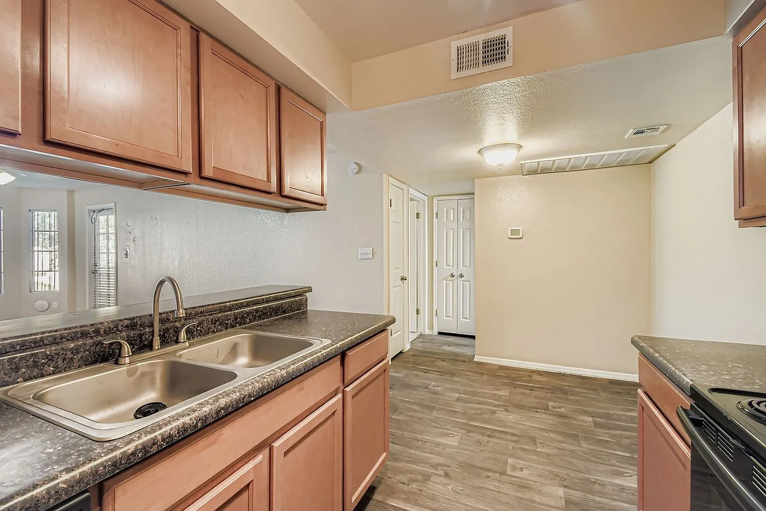 Kitchen, wood cabinetry, granite countertops, stainless steel sink, wood-style plank flooring