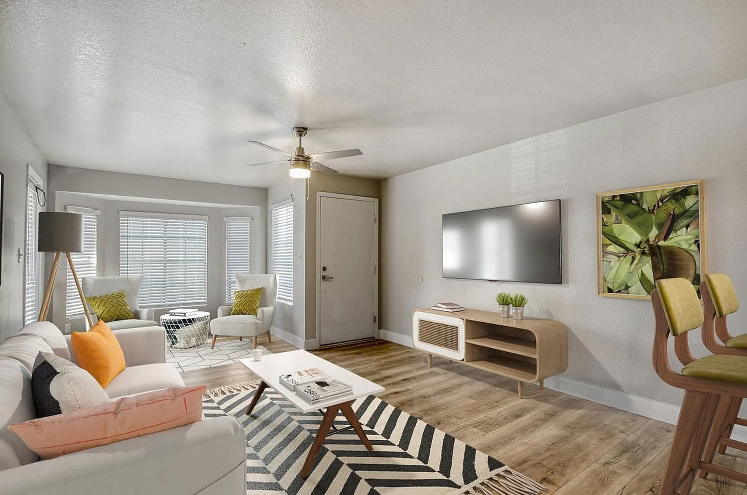 Living room, wood-style plank flooring, mounted flatscreen TV, striped area rug, ceiling fan