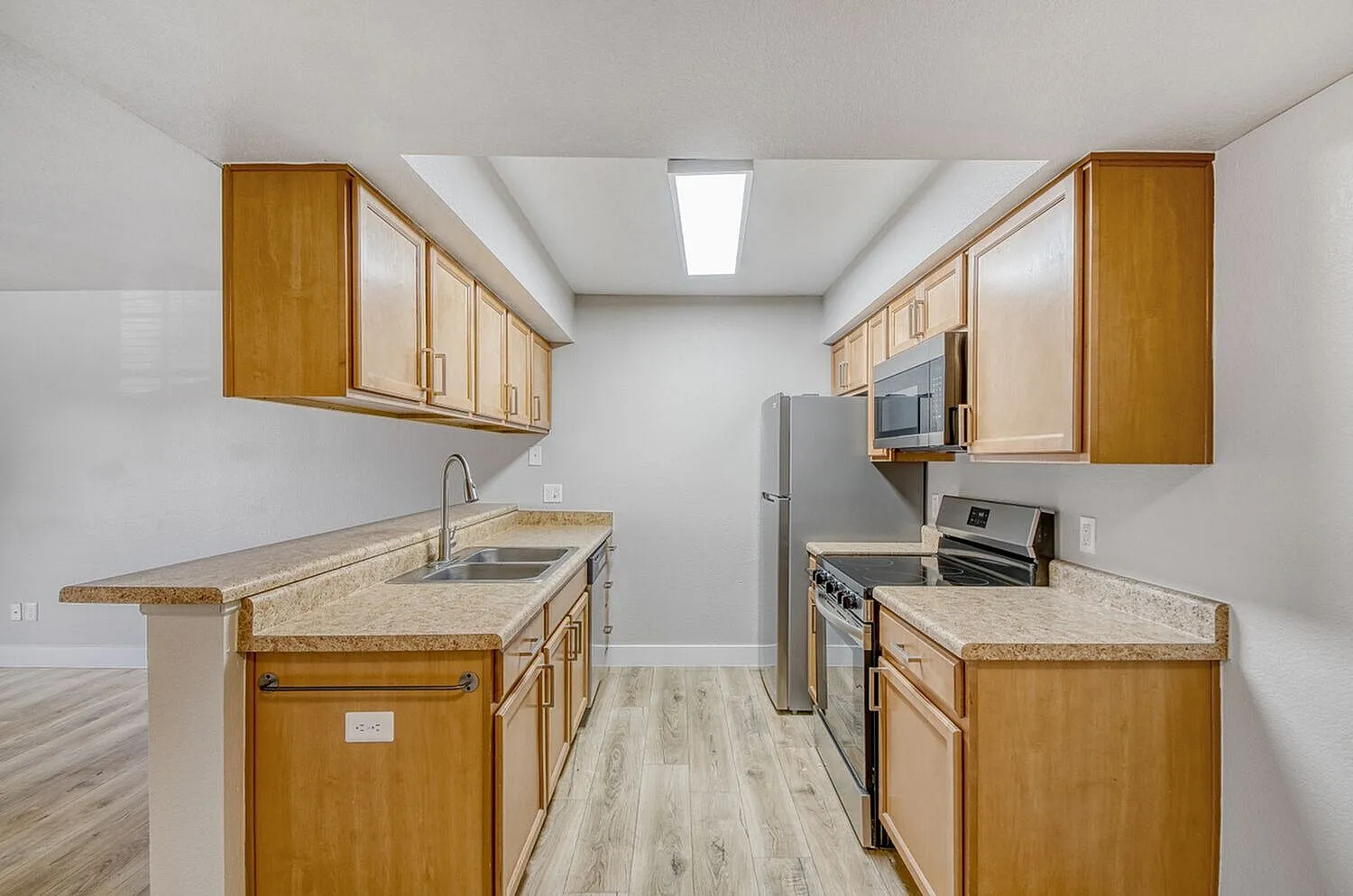 Kitchen, wood cabinetry, granite countertops, stainless appliances, wood-style plank flooring