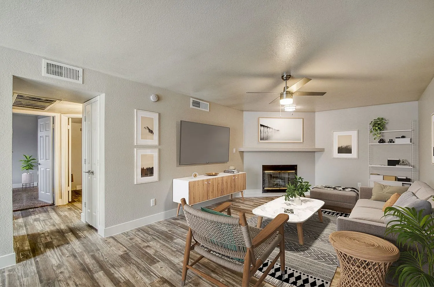 Living room, wood-style plank flooring, ceiling fan, fireplace, wall-mounted TV