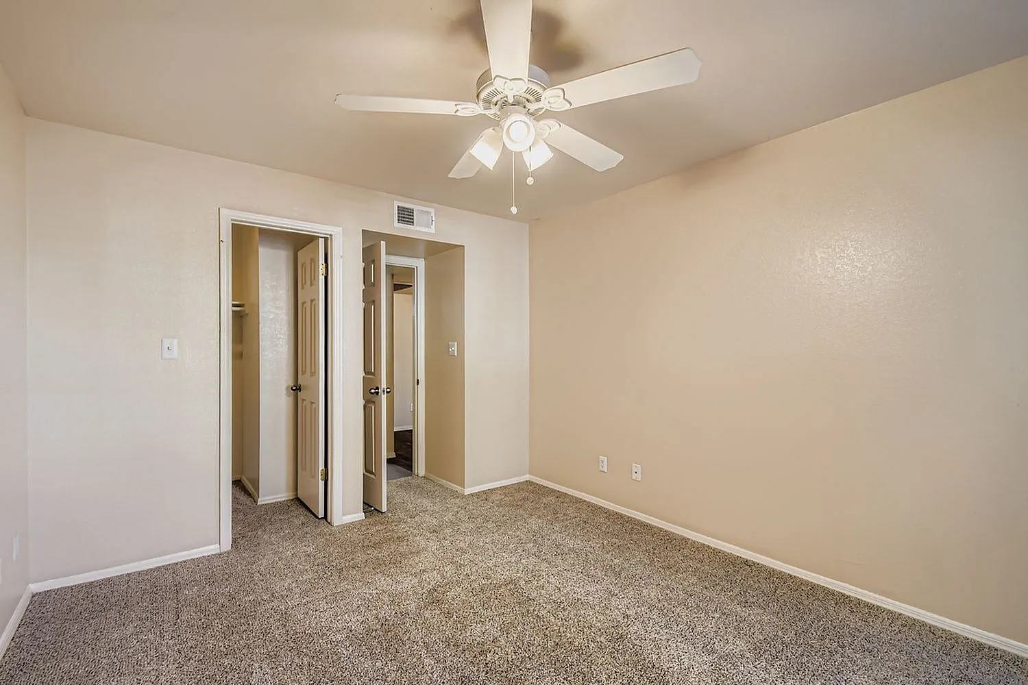 Primary bedroom, carpet flooring, ceiling fan with lights, double closets