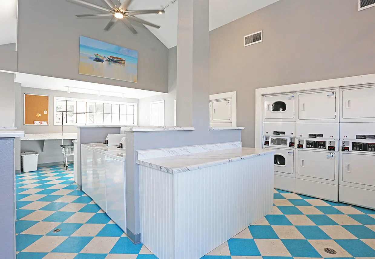Laundry room, blue and tan diamond tile flooring, front-load washers and dryers, ceiling fan