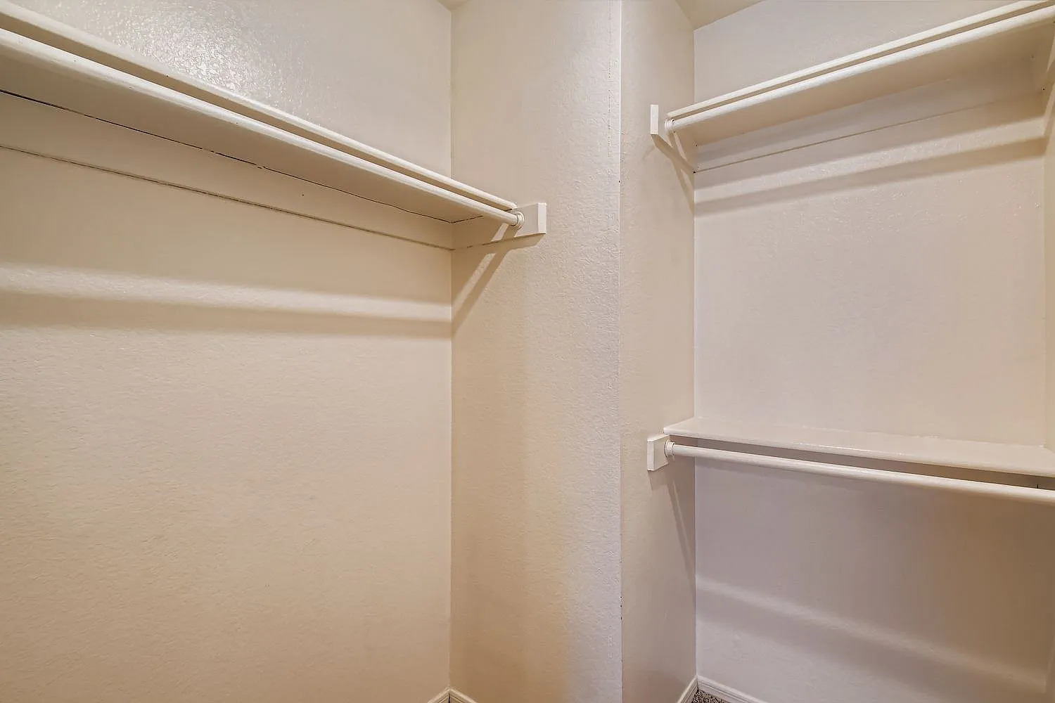 Walk-in closet, metal hanging rods, built-in shelving, white walls, LED lighting