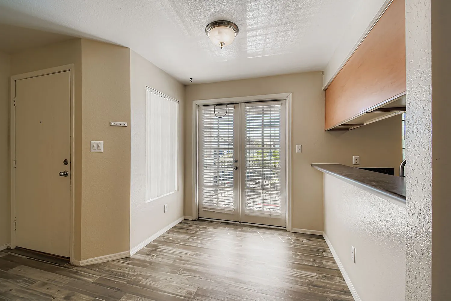 Kitchen and entryway, wood-style plank flooring, glass patio doors, open shelving