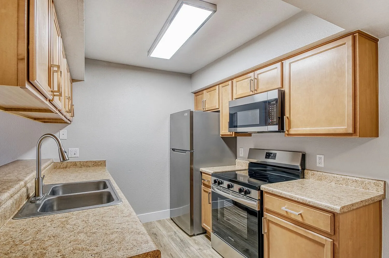 Kitchen, light wood cabinetry, granite countertops, stainless steel appliances, wood-style plank flooring