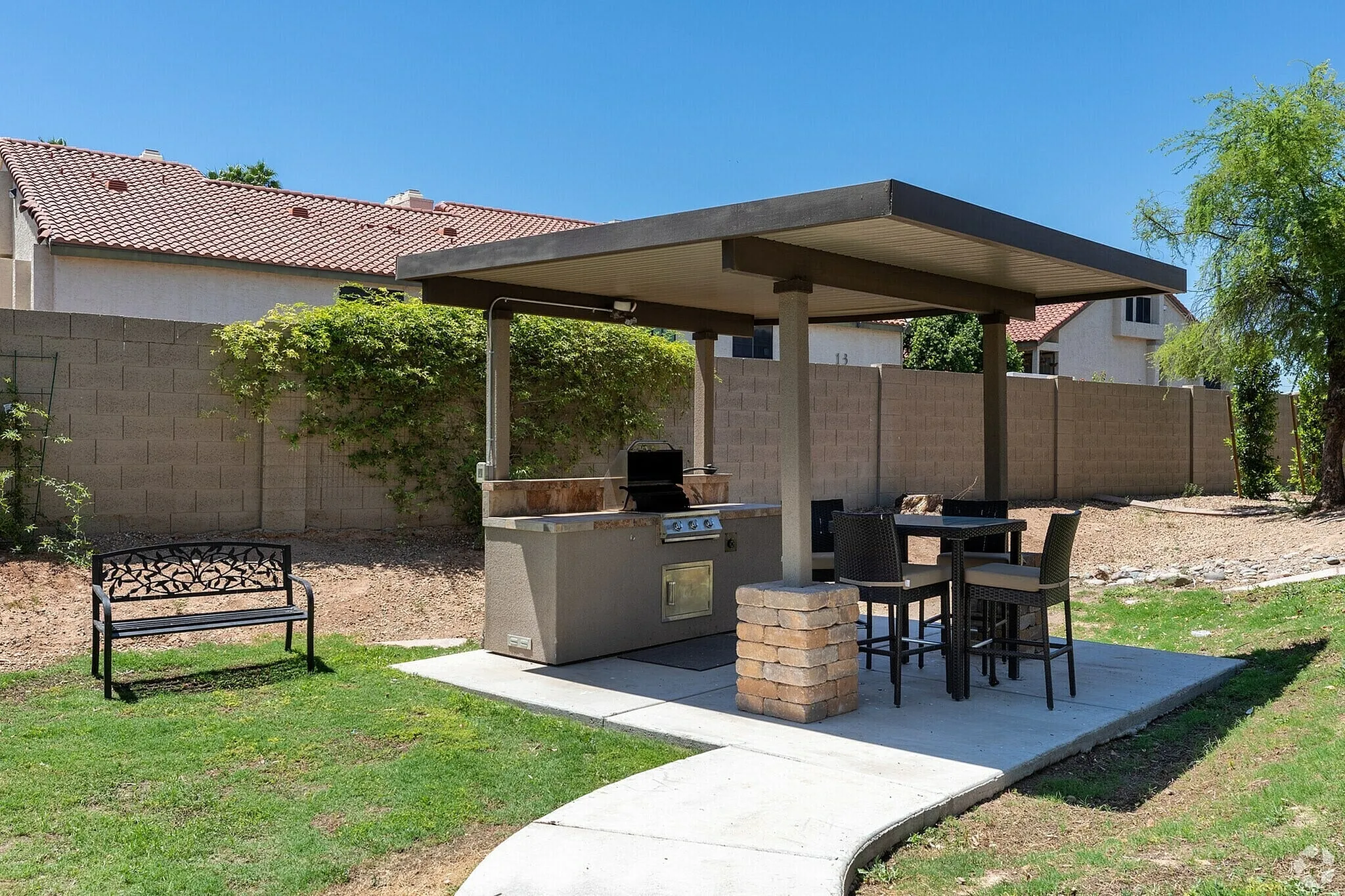 Covered patio with built-in grill, dining area, seating, concrete pad