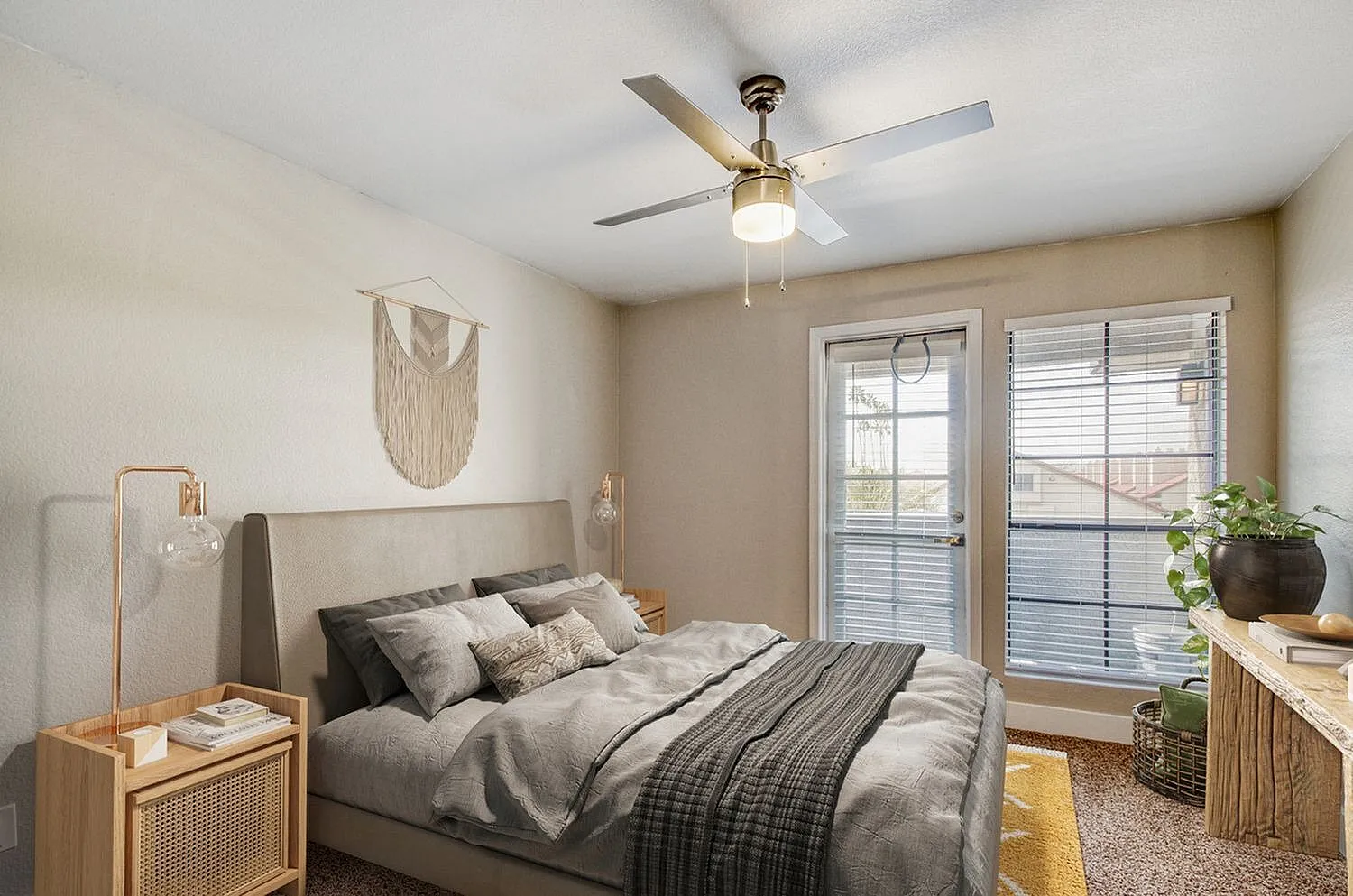 Primary bedroom, brass ceiling fan, glass doors to balcony, wood-style plank flooring